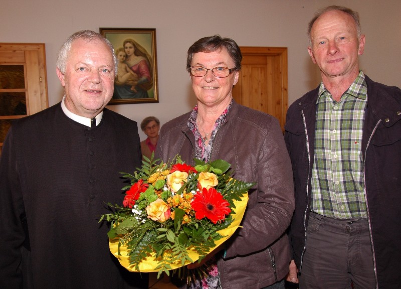 Pater Franz Hörmann (li)  und Pfarrgemeinderatsobmann Karl Huber (re) dankten Gerti Schatz (mi) mit einem Blumenstrauß